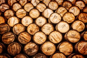 Detail view of stacked whisky and wine wooden barrels in vintage style